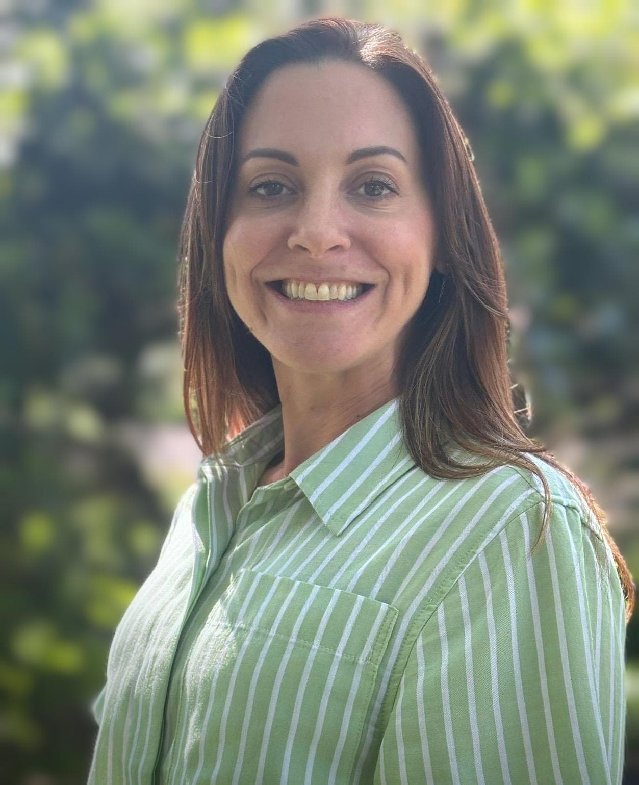 Leanne Windell, founder of Vision and Venture, smiling outdoors in a green striped shirt